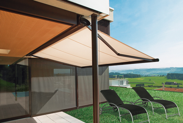 Moderne Terrassenüberdachung mit Markise und Sonnenliegen auf gepflegtem Rasen im Garten.